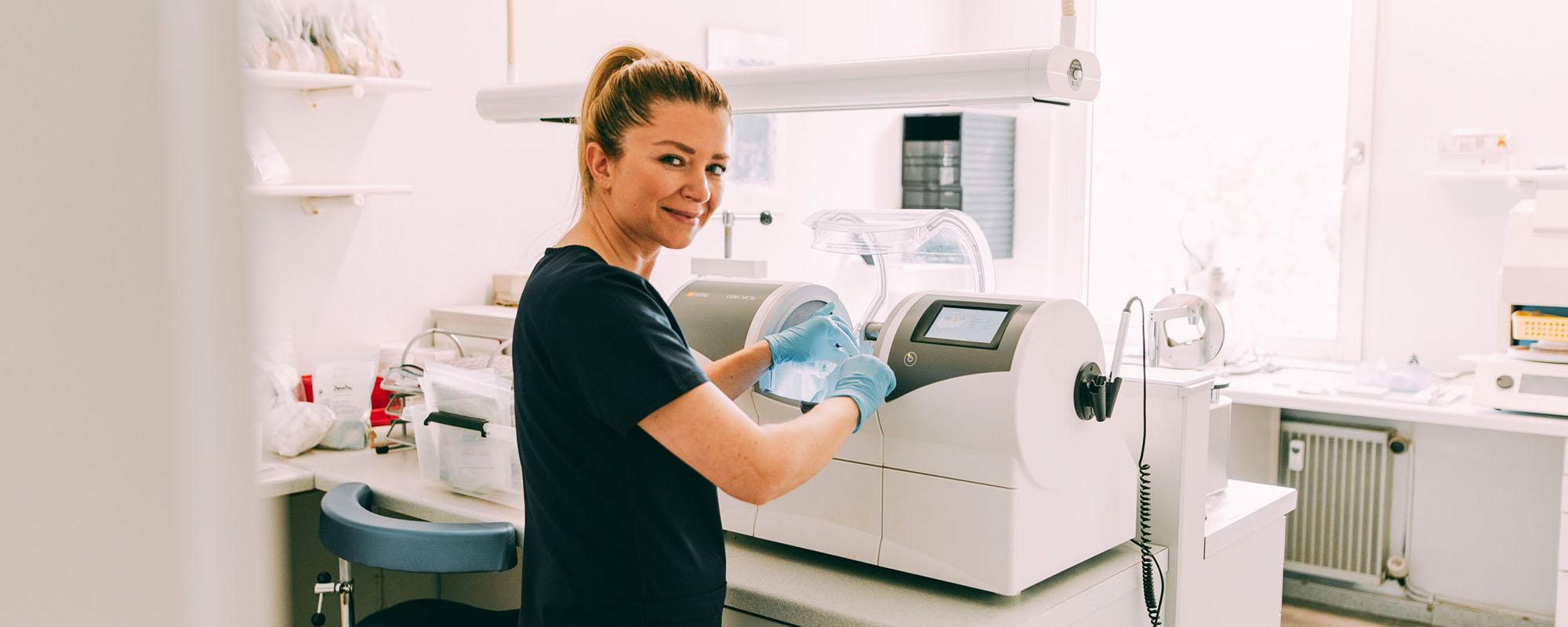 Eine Mitarbeiterin an einer Maschine in der Zahnarztpraxis Dr. Carolin Röder in Dinslaken